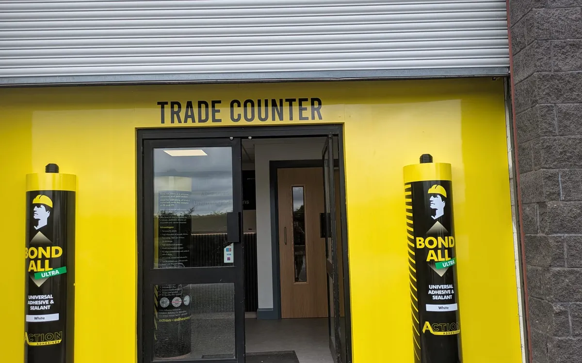 Action Adhesives trade counter shop front in bright yellow with two 5ft replica adhesive tubes flanking the entrance.