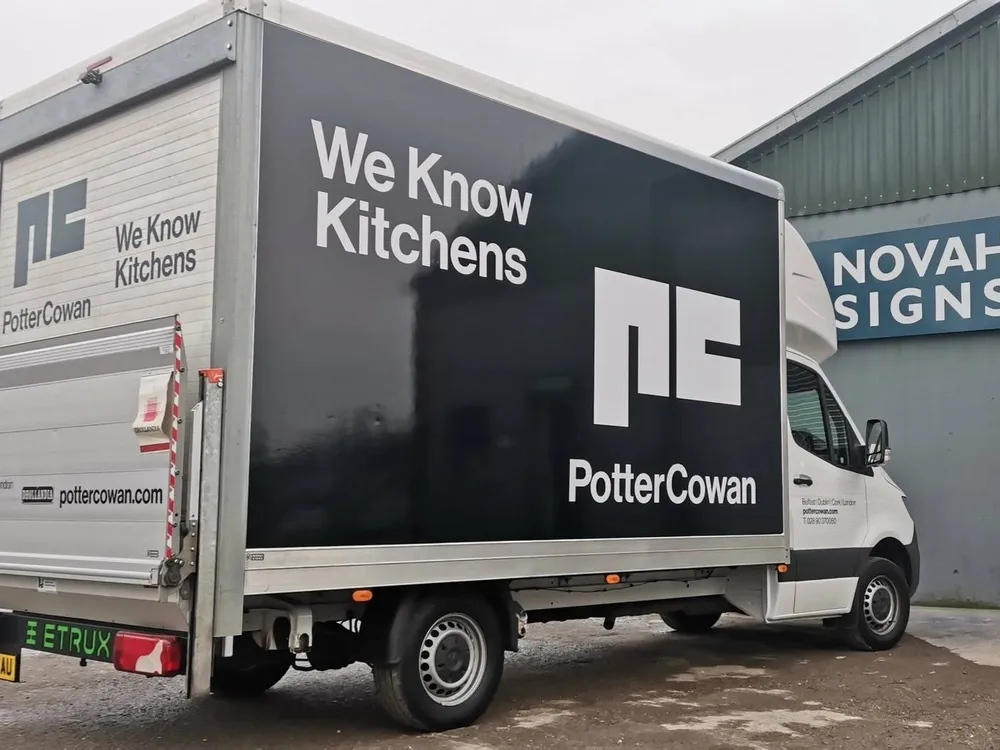 Potter Cowan box truck with a full vehicle wrap reading We Know Kitchens, photographed outside the Novah Signs workshop.